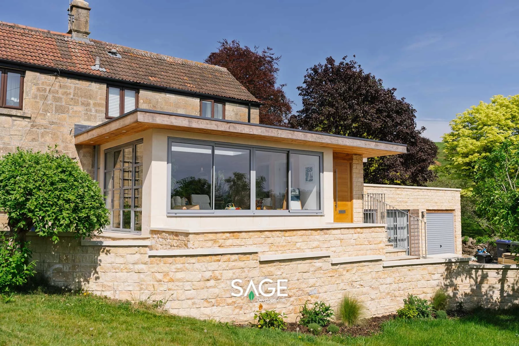View from the lower garden showing the structural retaining walls and new extension.