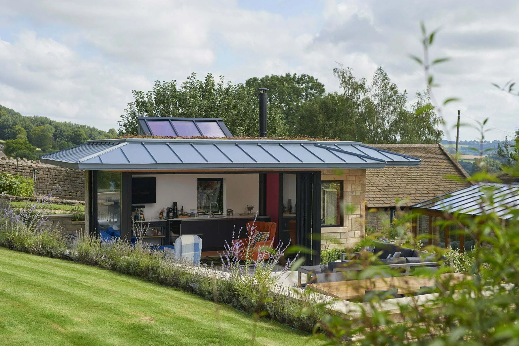 The garden studio retreat, showcasing the open plan interior set against the landscaped exterior.