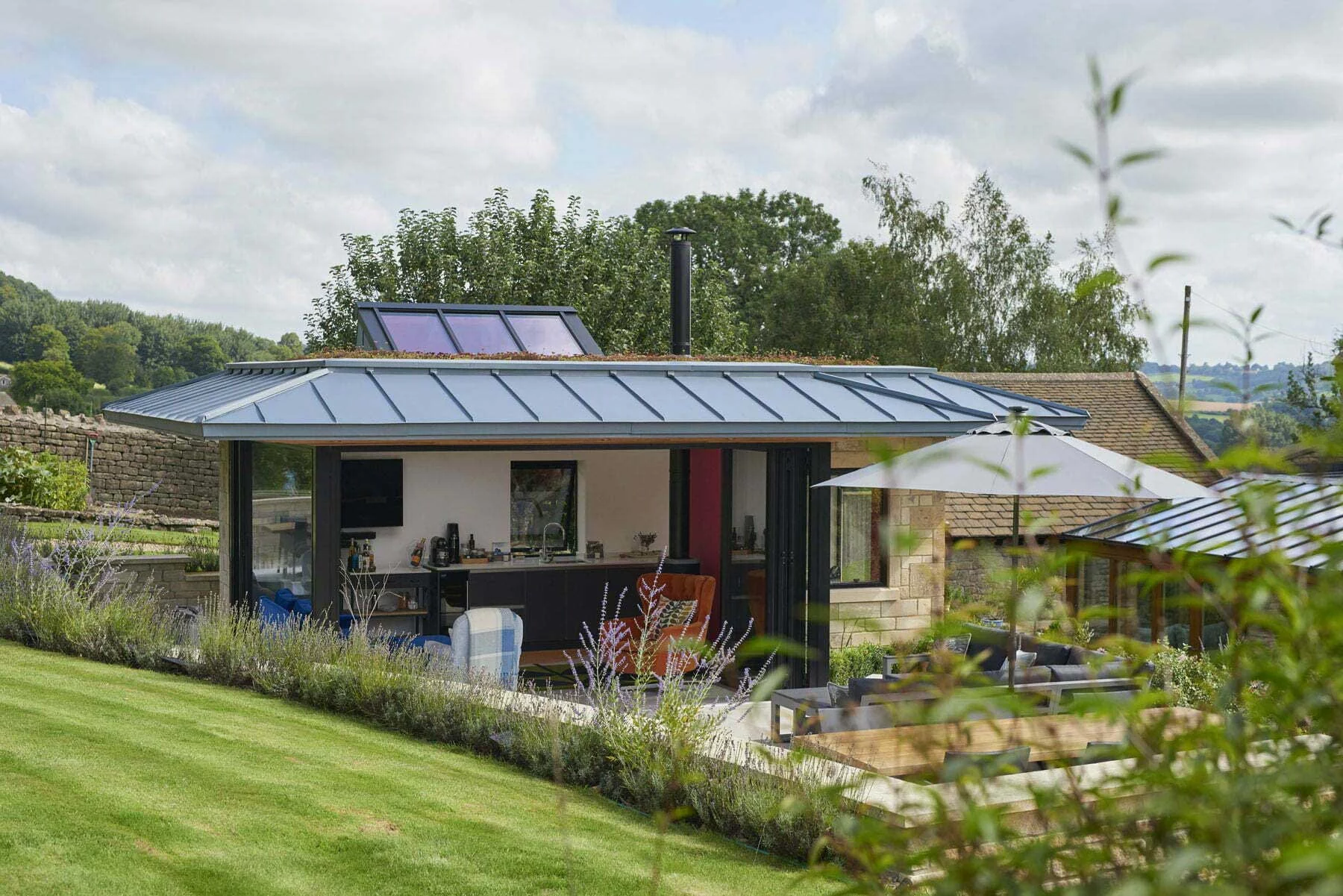 The garden studio retreat, showcasing the open plan interior set against the landscaped exterior.