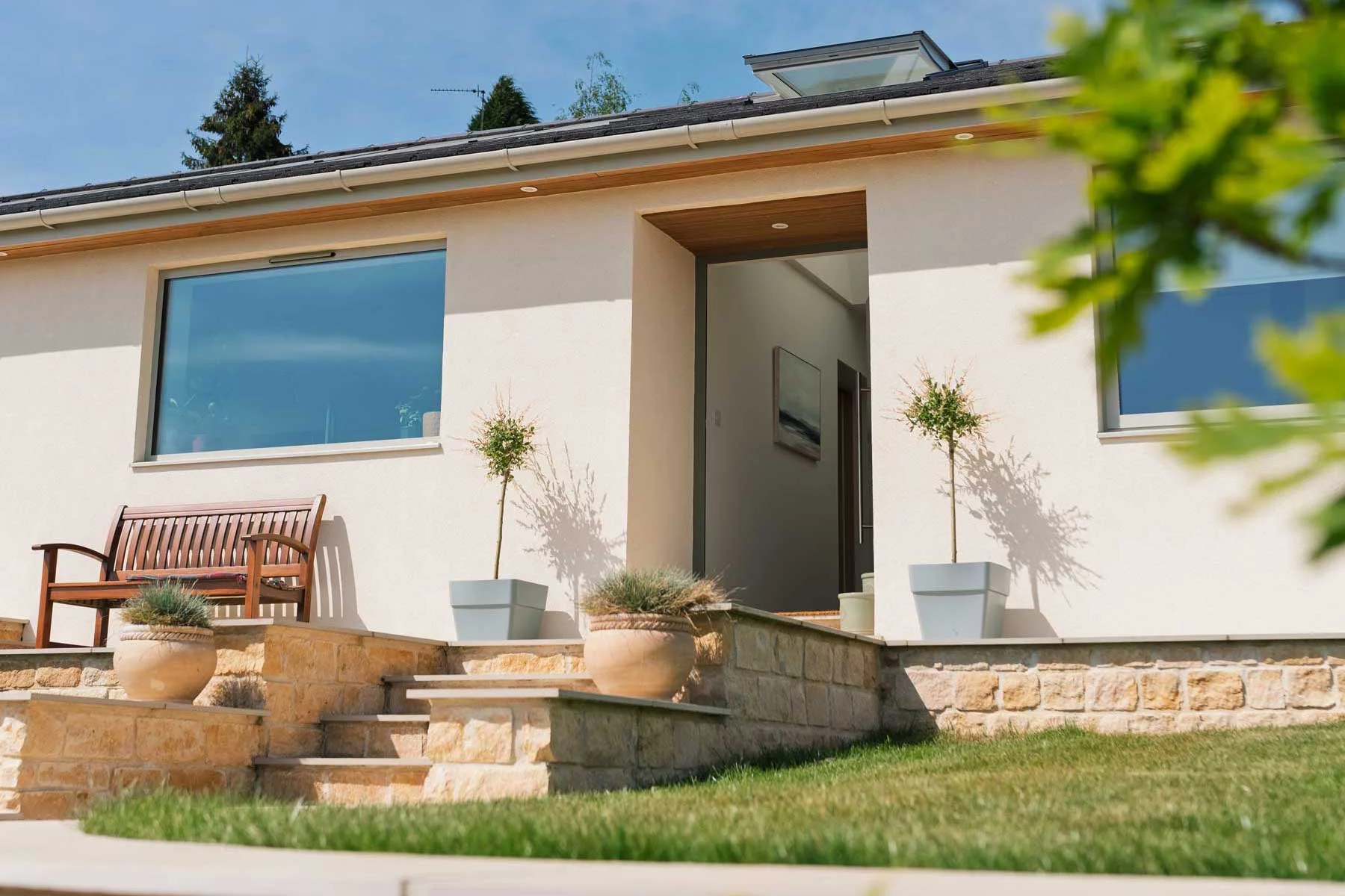 Wide-angle shot of the completed bungalow renovation and stone walling.